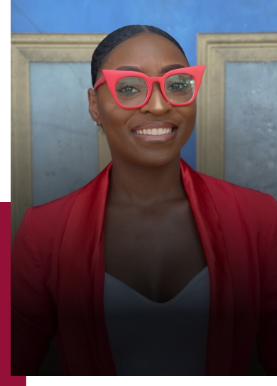 A young black woman radiates confidence and warmth as she smiles at the camera. She is elegantly dressed in professional, bright clothing, complemented by stylish red glasses that add a touch of vibrancy to her ensemble.